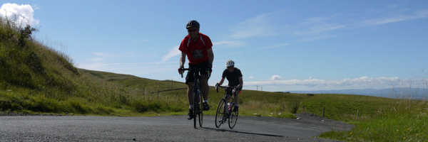 Two people taking on a cycling challenge